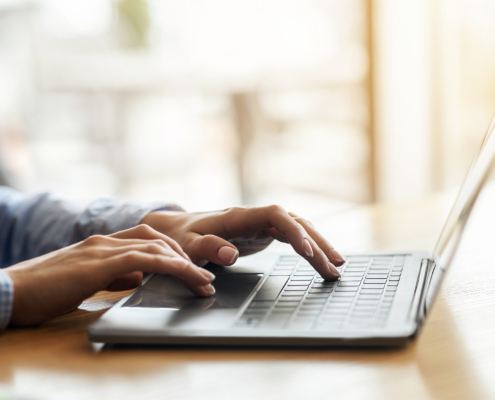 Female hands typing on laptop over blurred background