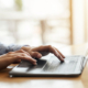 Female hands typing on laptop over blurred background