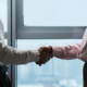 Header with colleagues shaking hands against panoramic