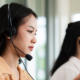 Team of call center staff in Asia wears headphones with a microphone